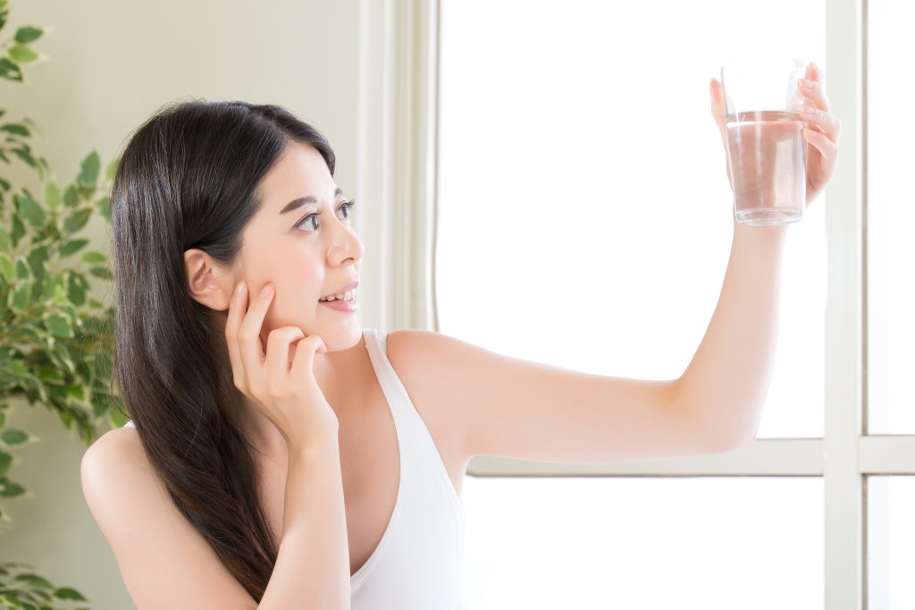 woman holding up glass of water